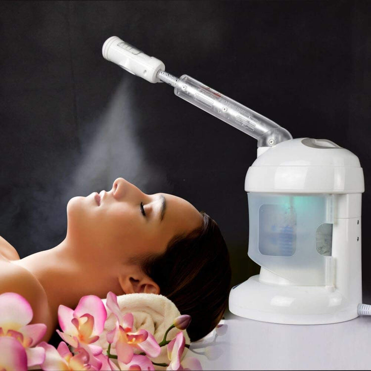 Woman receiving facial steam treatment with a white facial steamer on a dark background
